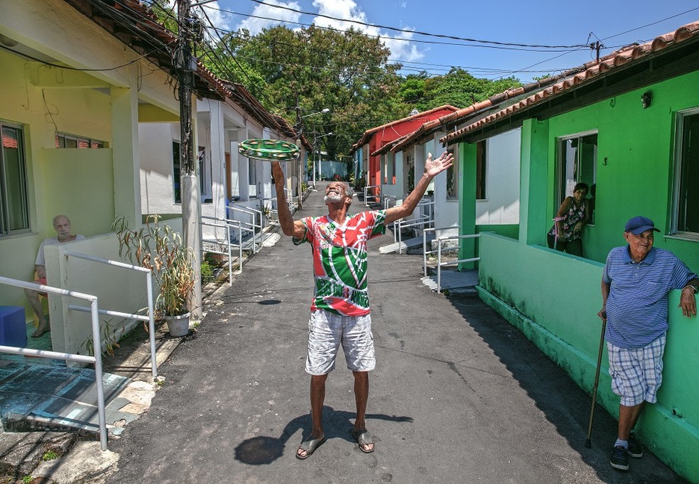 Moradores e casas coloridas no Retiro dos Artistas: luta para ficar no azul — Foto: Leo Aversa