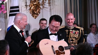 Joe Biden entrega ao presidente sul-coreano Yoon Suk Yeol guitarra autografada pelo cantor americano Don McLean como presente  — Foto: Brendan Smialowski/AFP