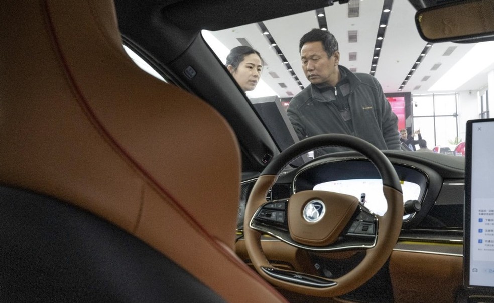 Uma vendedora e um cliente em uma concessionária de automóveis BYD em Shenzhen, China, em janeiro — Foto: Gilles Sabrié/The New York Times
