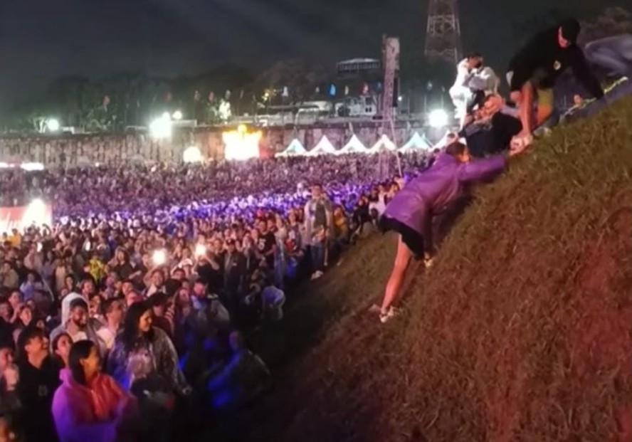 Mulher tenta escalar morro no Lollapalooza, incentivada pela multidão