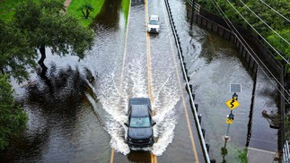 Veículos tentam viajar em uma estrada inundada em Tampa, Flórida, EUA — Foto: Miguel J. Rodríguez Carrillo/AFP