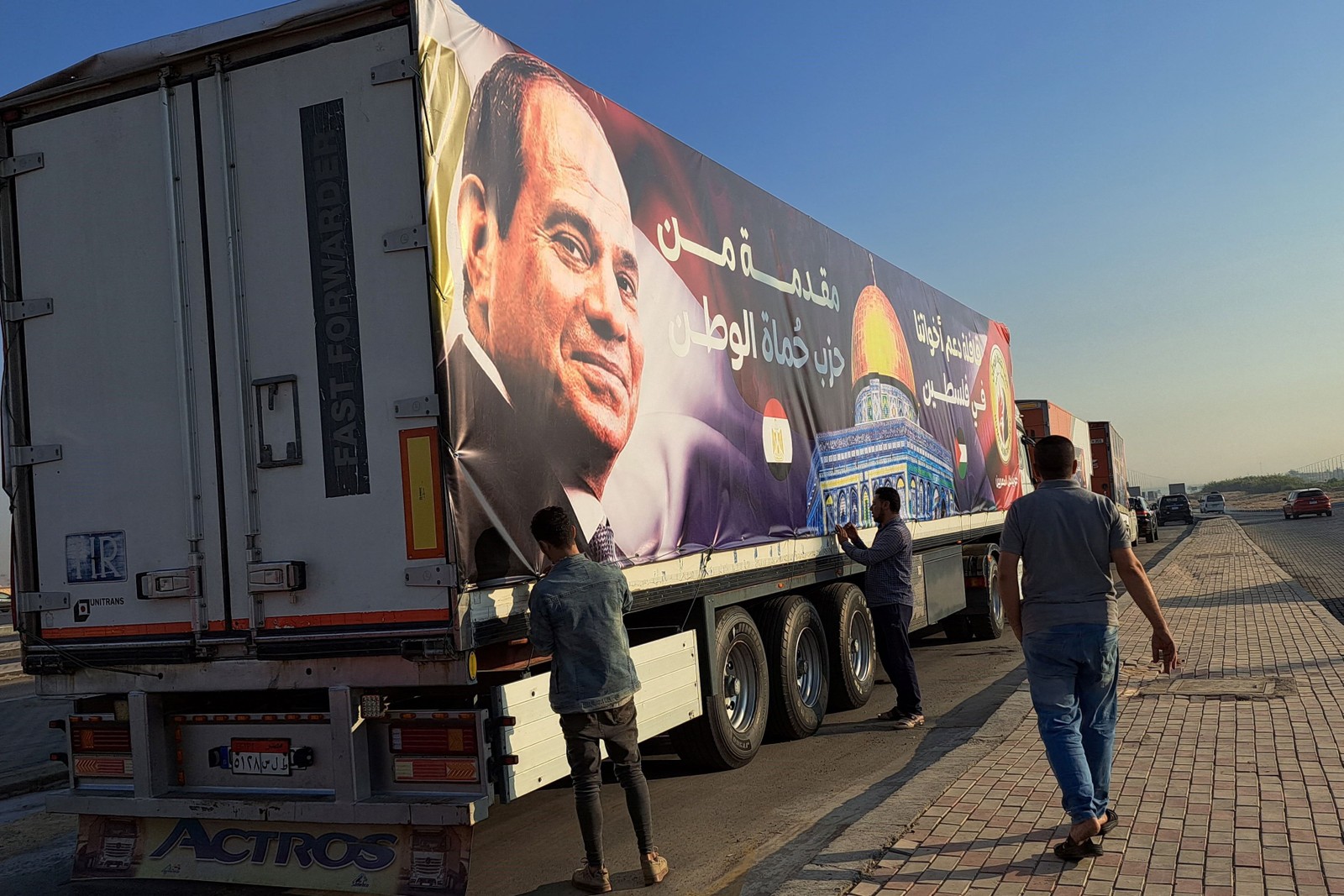 Caminhões com ajuda humanitária na fronteira; alguns levam foto do presidente egípcio, Abdel Fattah al-Sisi — Foto: Khaled DESOUKI / AFP