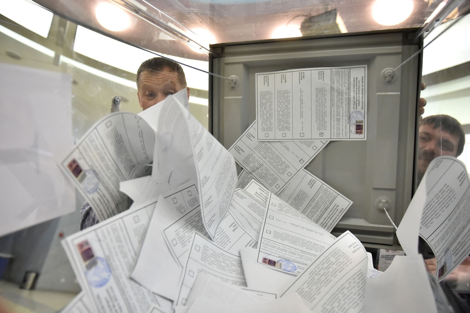 Membros de uma comissão eleitoral contam cédulas de votação em uma seção eleitoral em Novosibirsk em 17 de março de 2024. — Foto: Vladimir NIKOLAYEV / AFP