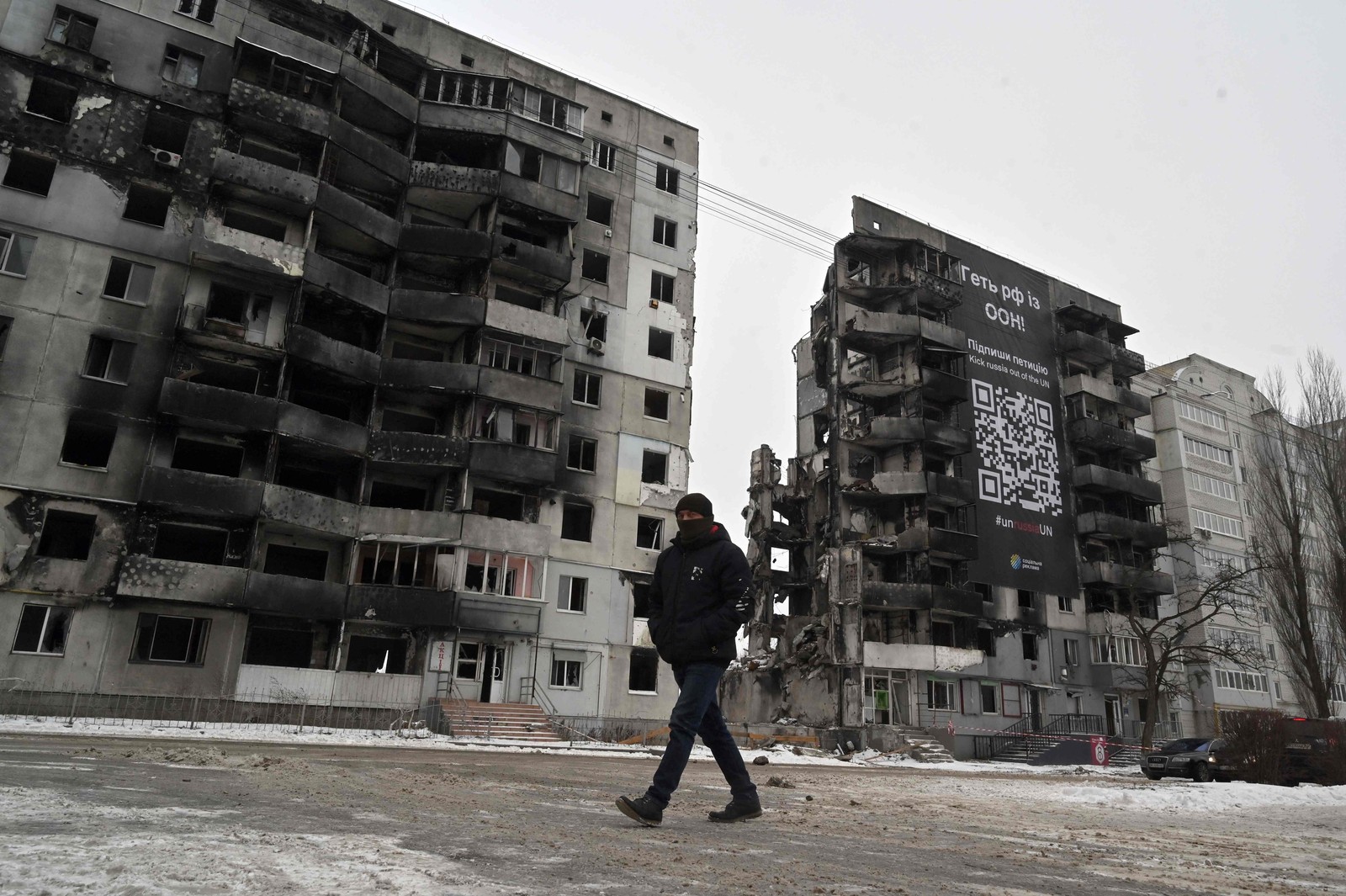 Homem passa por edifícios destruídos na pequena cidade ucraniana de Borodyanka, a cerca de 60 km da capital ucraniana, Kiev, em meio à invasão russa da Ucrânia.  — Foto: Sergei SUPINSKY / AFP