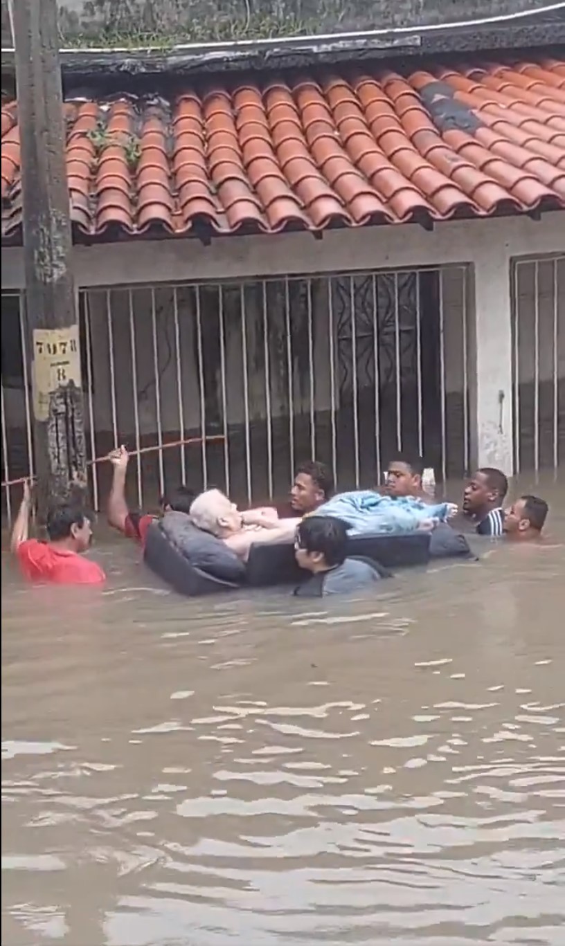 Com água até o pescoço, grupo resgata idoso durante a forte chuva no bairro Jardim América — Foto: Reprodução / Redes Sociais