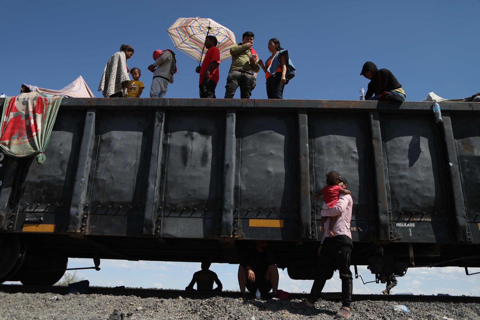 Migrantes, principalmente da Venezuela, permanecem retidas depois que o trem de mercadorias em que viajavam para Ciudad Juarez parou no deserto do município de Ahumada, estado de Chihuahua, México, em 29 de setembro de 2023. Nos últimos 11 meses, pelo menos 1,8 milhão pessoas chegaram à fronteira sul dos EUA, muitas delas em busca de segurança e oportunidades económicas. — Foto: HERIKA MARTINEZ/AFP