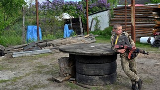 Crianças usam coletes à prova de balas feitos em casa durante 'brincadeiras' de guerra — Foto: Sergei Supinsky/AFP