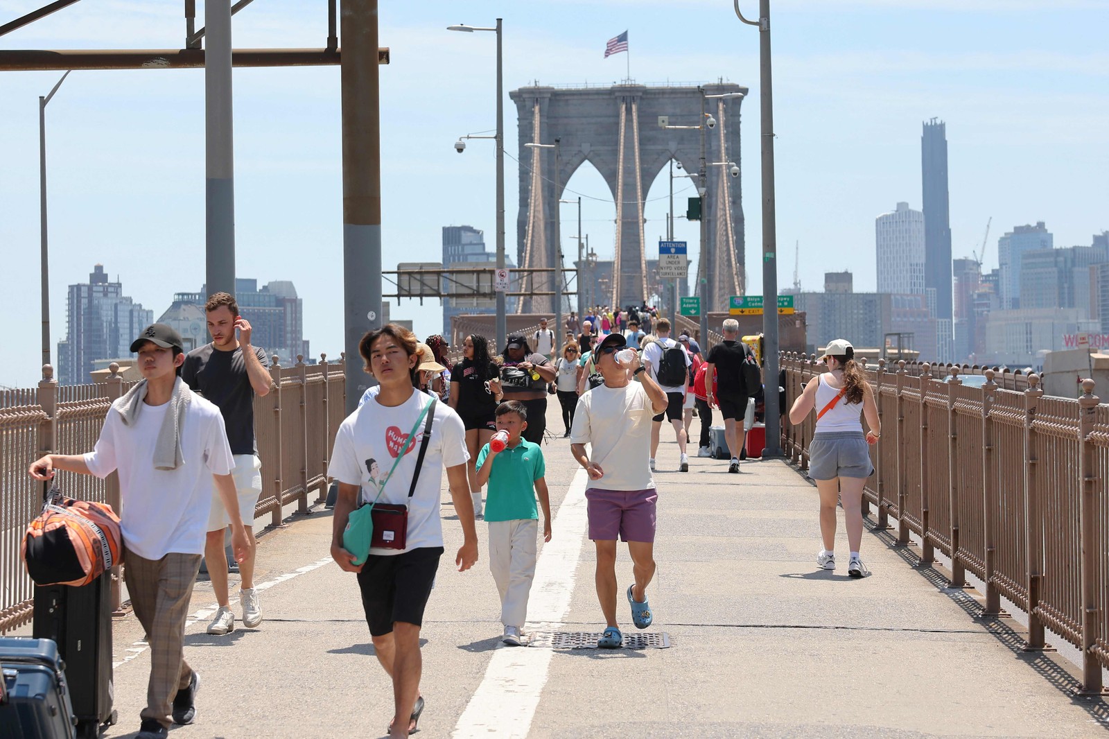 Pessoas caminham ao longo da Ponte do Brooklyn em meio a uma onda de calor  na cidade de Nova York. — Foto: Michael M. Santiago/Getty Images/AFP