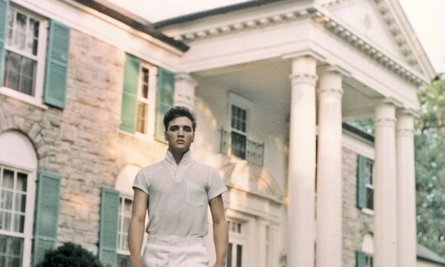 Elvis Presley em frente à mansão Graceland, em Memphis, Tennessee, onde viveu por 20 anos, até sua morte em 1977