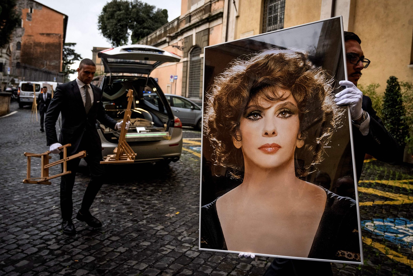 Funcionários carregam foto para velório da atriz italiana Gina Lollobrigida, no Monte Capitolino de Roma — Foto: Tiziana FABI / AFP