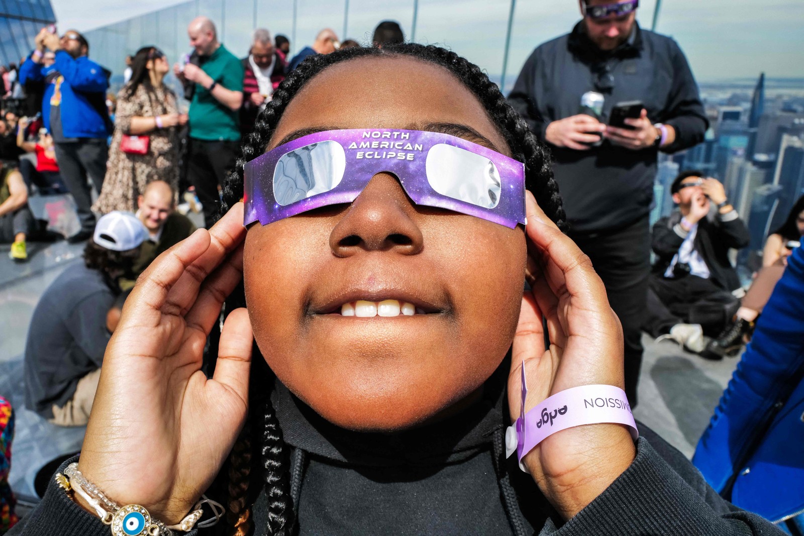 Uma jovem olha para o céu no deck de observação 'Edge at Hudson Yards' durante o eclipse solar na cidade de Nova York. — Foto: CHARLY TRIBALLEAU / AFP