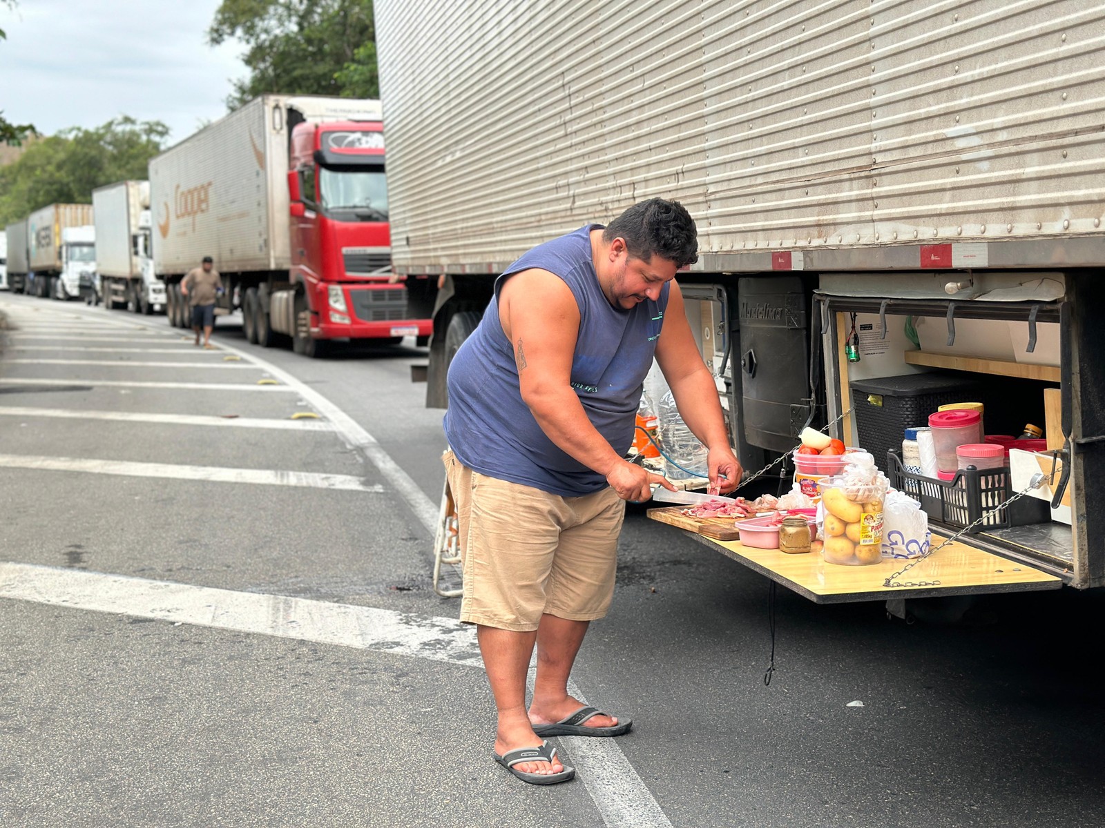 Caminhoneiro Gerson Fernandes aproveitou o trânsito parado na Serra das Araras para preparar o almoço — Foto: Márcia Foletto