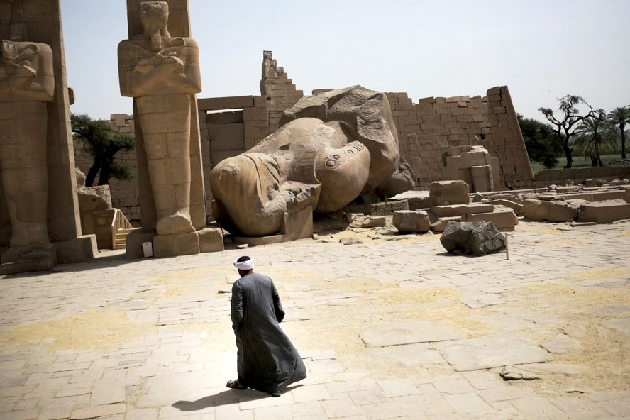 Homem caminha dentro do Ramesseum, o templo mortuário do faraó Ramsés II