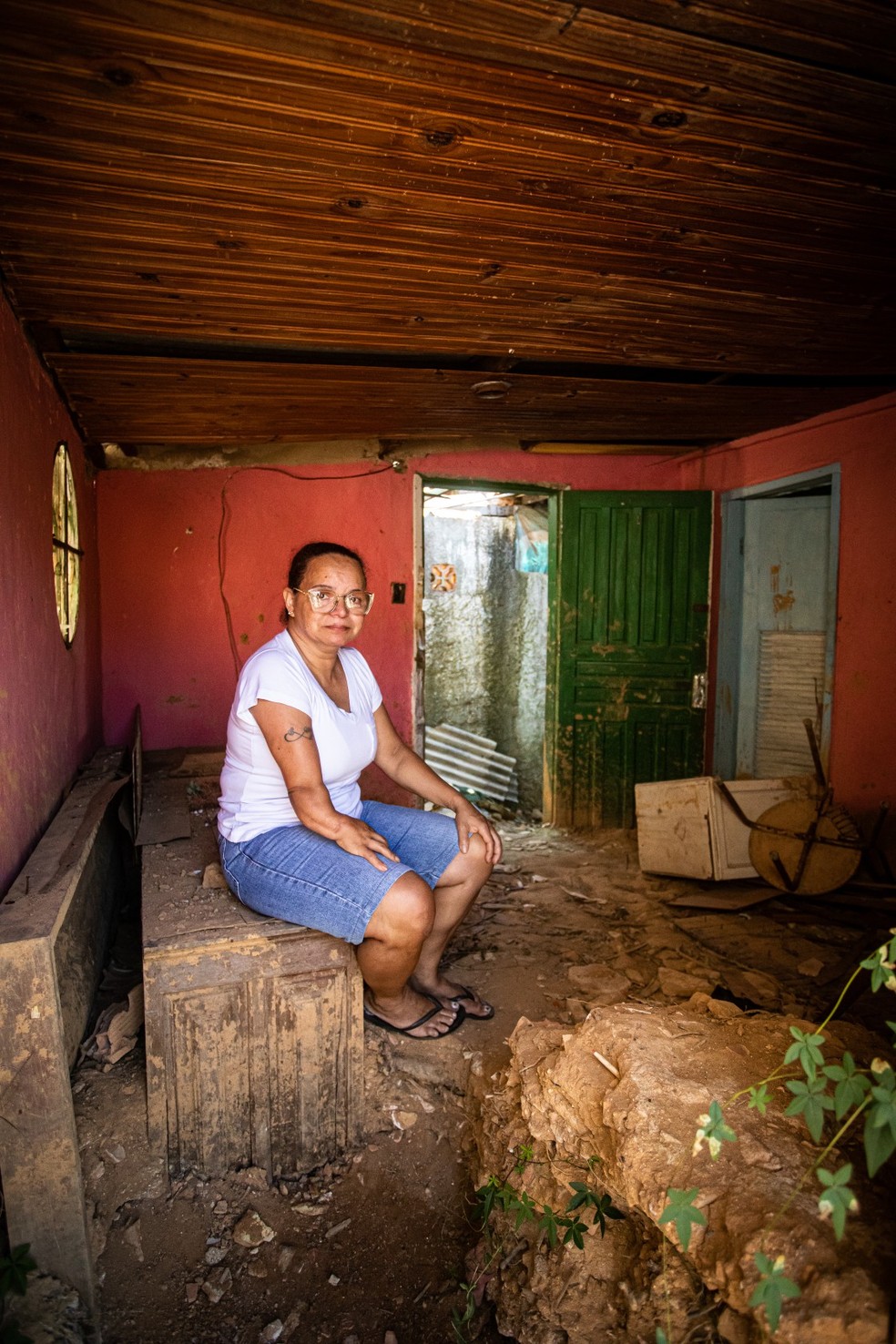 Destruída. A auxiliar de limpeza Ivonice de Souza no que sobrou da casa da mãe — Foto: Hermes de Paula/Agência O Globo