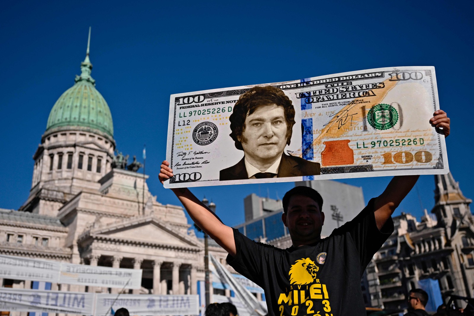 Um dos apoiadores de Javier Milei levou uma cédula estampada com o rosto do presidente eleito — Foto: Luis ROBAYO / AFP