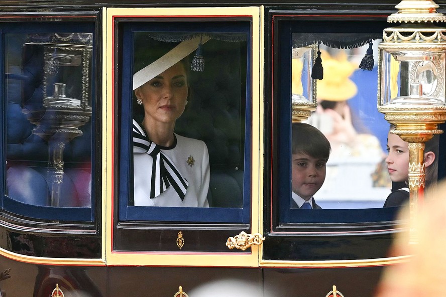 Princesa Kate com o príncipe Louis e a princesa Charlotte dentro da carruagem a caminho do Desfile da Guarda Montada.