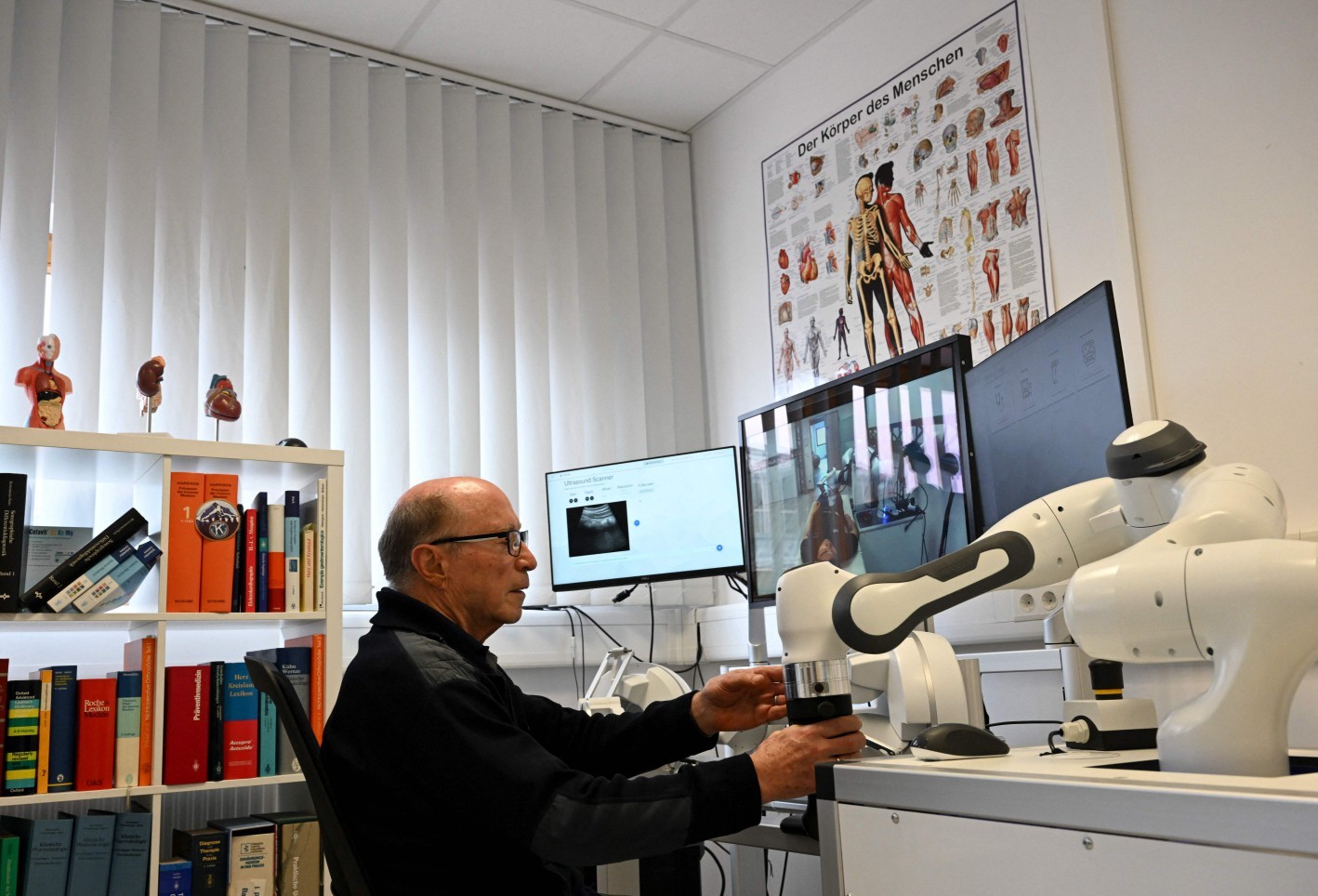 Médico Guenter Steinebach trabalha com o auxílio de um robô — Foto: Christof STACHE / AFP