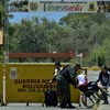 Mulher venezuelana em uma cadeira de rodas é ajudada por um membro da Guarda Nacional Venezuelana na ponte internacional Simon Bolivar após o fechamento da fronteira Colômbia-Venezuela - Schneyder Mendoza / AFP