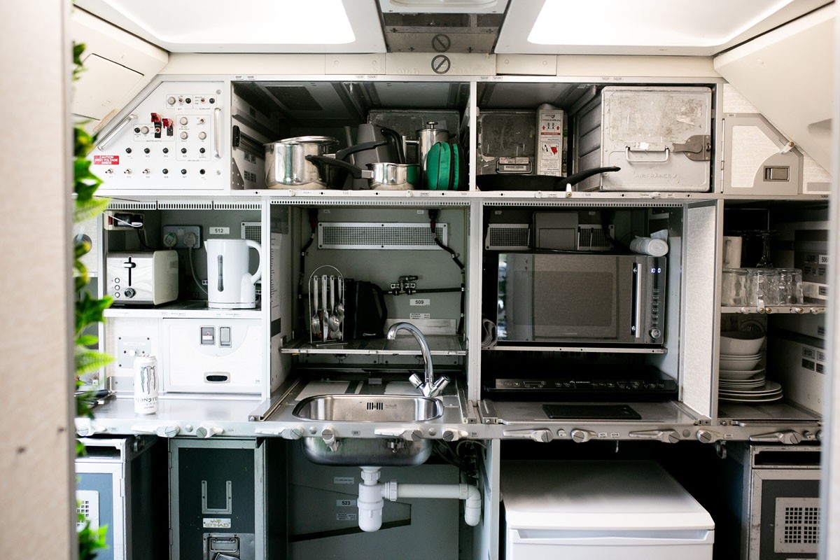 A cozinha do avião desativado está operacional, com pia, geladeira e micro-ondas — Foto: Reprodução / Apple Camping