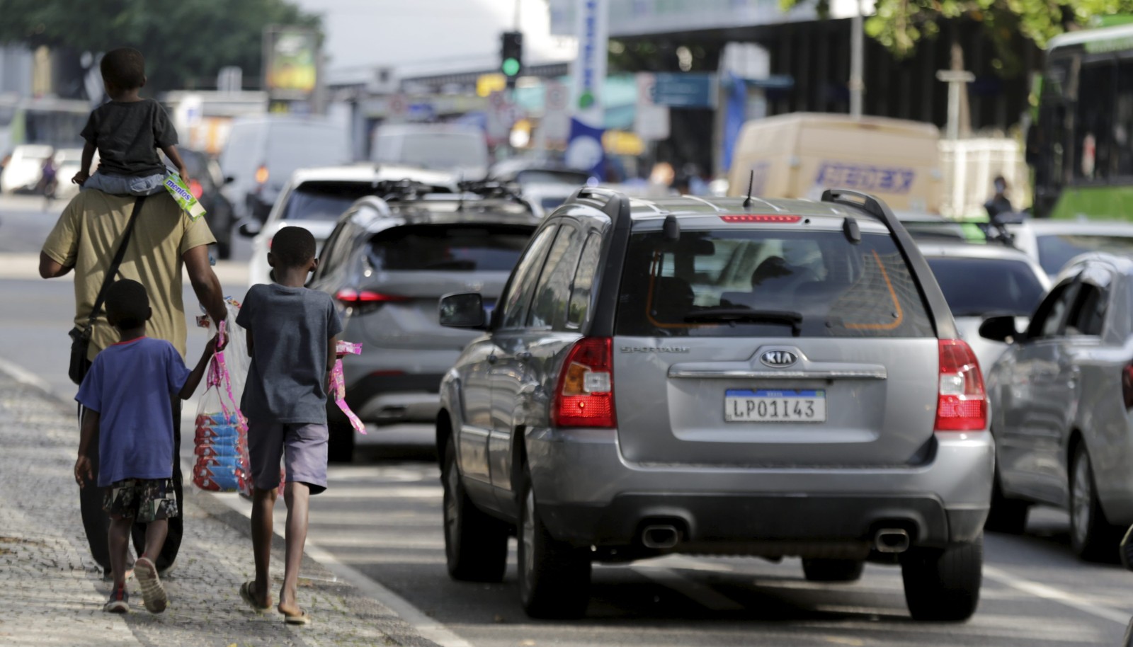 Flávio Paulo, com seus três filhos, ganha a vida vendendo pipoca e doces na Avenida Presidente Vargas. "Prefiro trazer as crianças para ficar perto de mim, assim protejo mais elas" — Foto: Domingos Peixoto / Agência O Globo