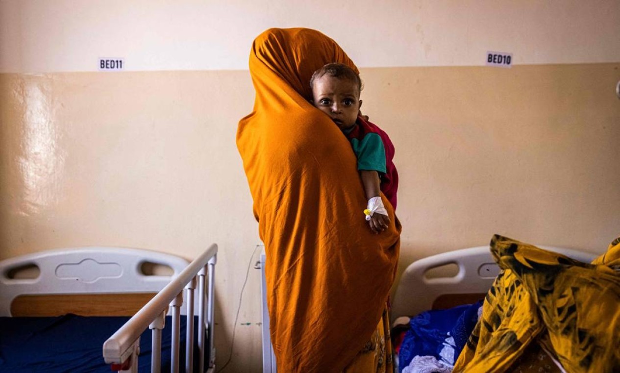Mãe segura seu bebê desnutrido na Maternidade e Hospital Infantil Banadir em Mogadíscio, Somália, que enfrenta grave seca há quatro estações seguidas — Foto: ED RAM / AFP