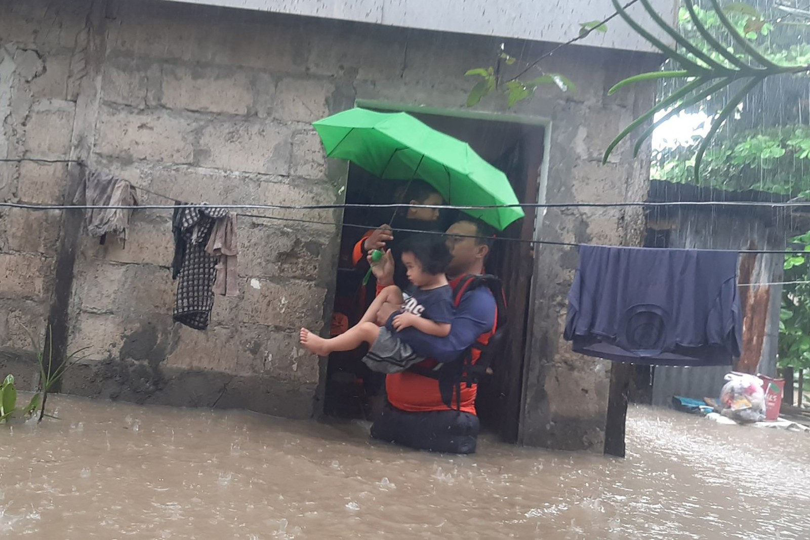 Guarda Costeira das Filipinas resgata criança de uma área inundada na cidade de Ozamiz. Tempestade no Natal deixou mais de 46 mil desabrigados — Foto: GUARDA COSTEIRA FILIPINA/AFP