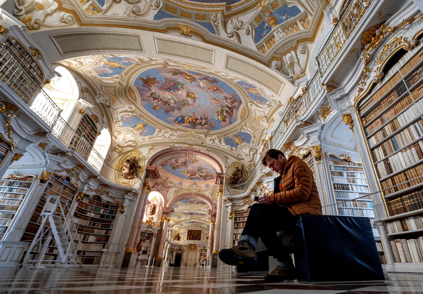Um visitante no hall principal da biblioteca da Abadia de Admont, que fica na Áustria e é considerada uma das mais bonitas do mundo — Foto: Joe Klamar / AFP