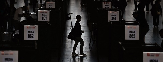 Mulher caminha entre seções eleitorais durante o plebiscito para a nova proposta de Constituição do Chile, em Santiago, em 17 de dezembro de 2023 — Foto: Pablo Vera / AFP