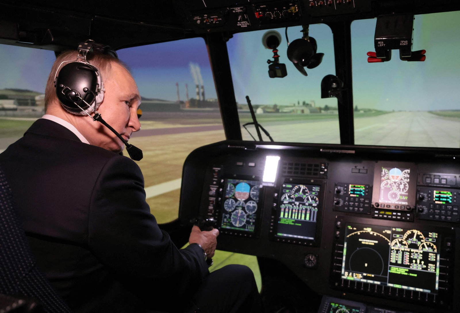 Presidente russo, Vladimir Putin, opera um simulador de voo de helicóptero Mi-171A2 no centro de treinamento de uma fábrica de aviação na Sibéria — Foto: MIKHAIL METZEL/AFP