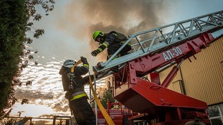 Bombeiros apagam incêndio em um armazém de produção em Kharkiv após um ataque noturno com mísseis na Ucrânia — Foto: AFP