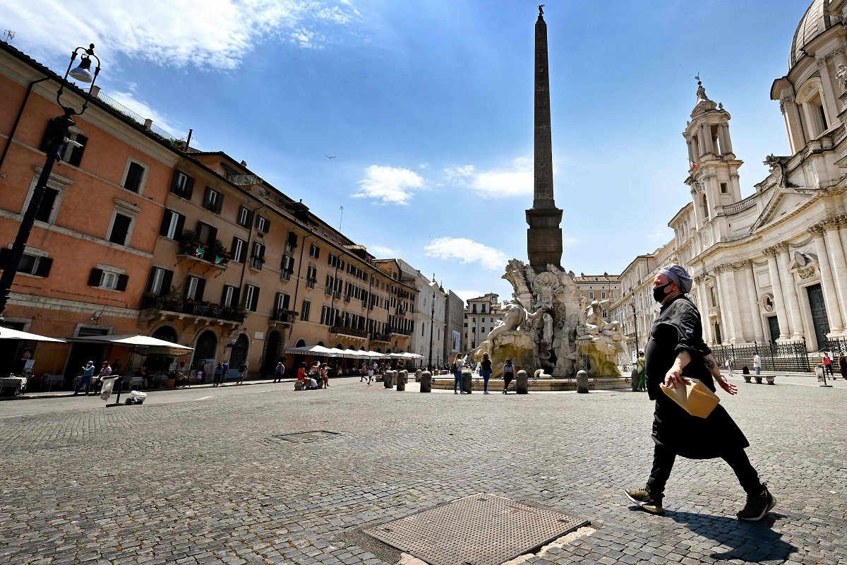 Um chef de cozinha caminha pela Piazza Navona, em RomaAFP