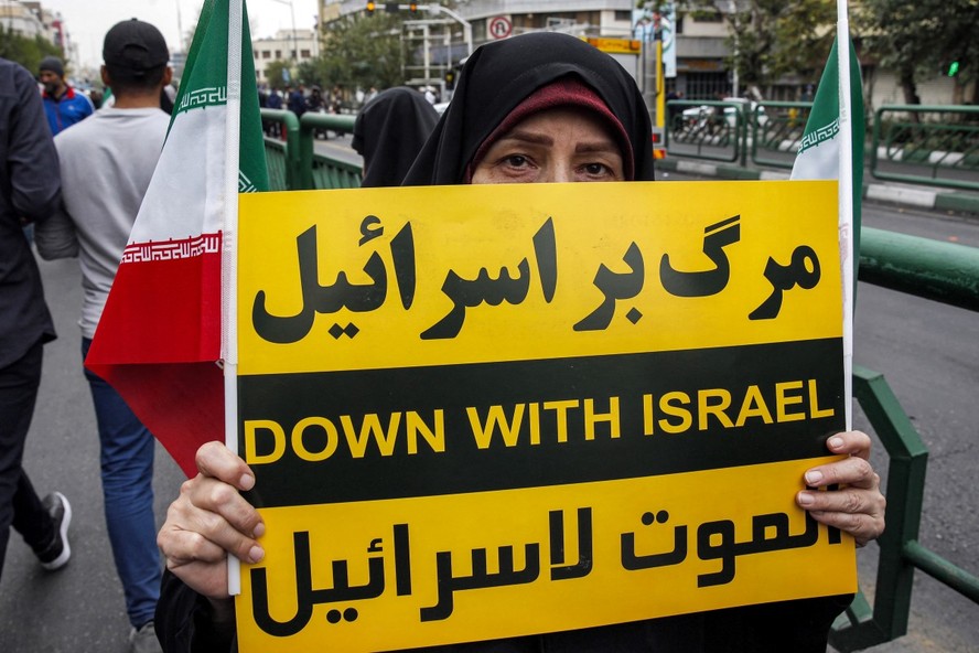 Mulher segura placa condenando Israel durante manifestação anti-israelense para mostrar solidariedade ao povo palestino em Teerã, no Irã