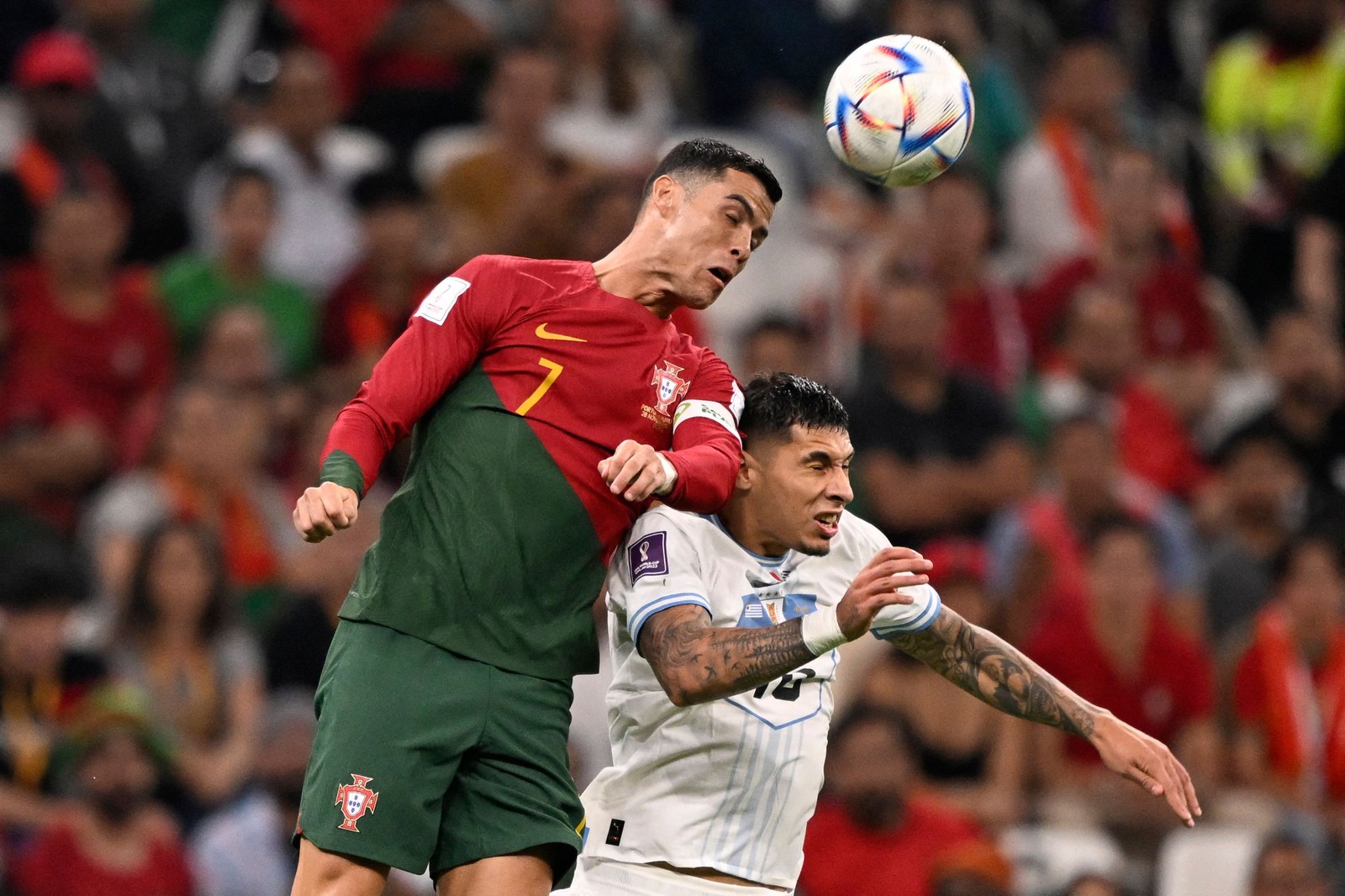 Cristiano Ronaldo cabeceia a bola sobre o zagueiro uruguaio Mathias Olivera  — Foto: PATRICIA DE MELO MOREIRA / AFP