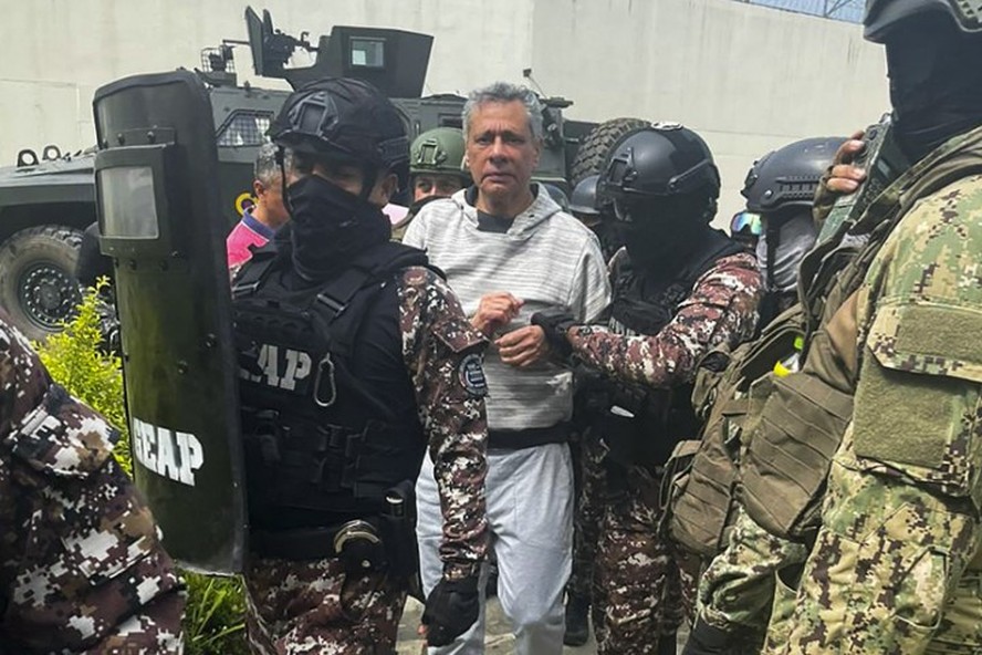 Jorge Glas é escoltado por agentes penitenciários durante chegada à prisão de segurança máxima La Roca, em Guayaquil