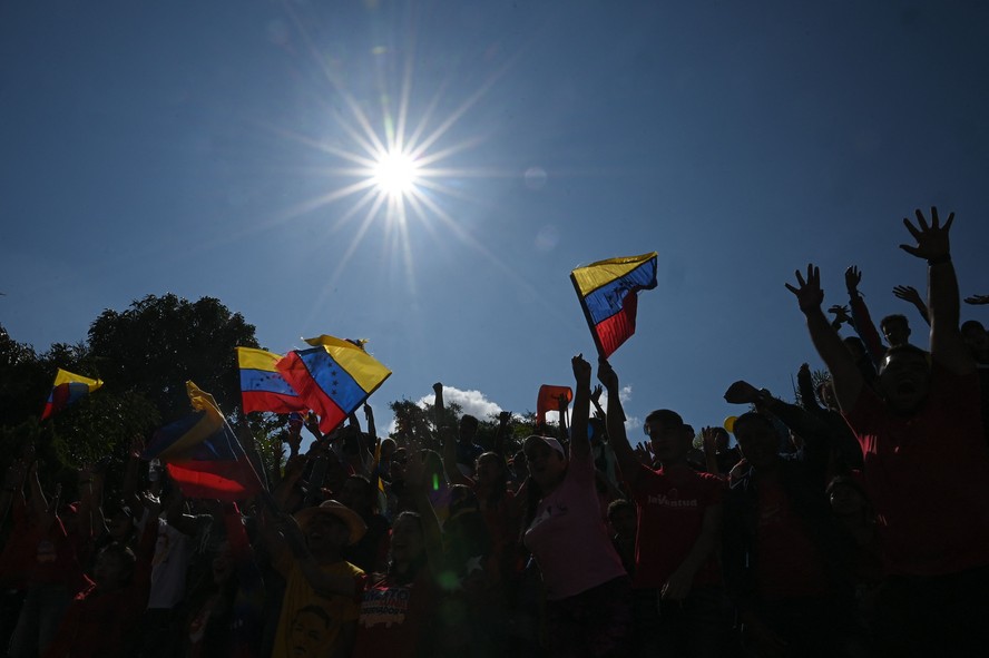 Venezuelanos agitam bandeiras nacionais enquanto participam de uma marcha no Dia Internacional da Juventude em Caracas