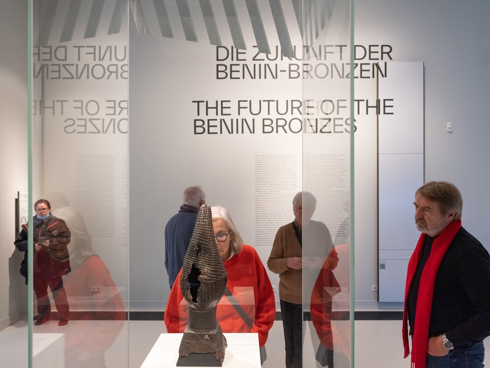 Visitantes do museu Forum Humboldt, em Berlim, observam uma das esculturas de bronze de Benin; algumas delas datam de até o século XIII e foram roubados por tropas imperiais britânicas — Foto: Andreas Meichsner/The New York Times