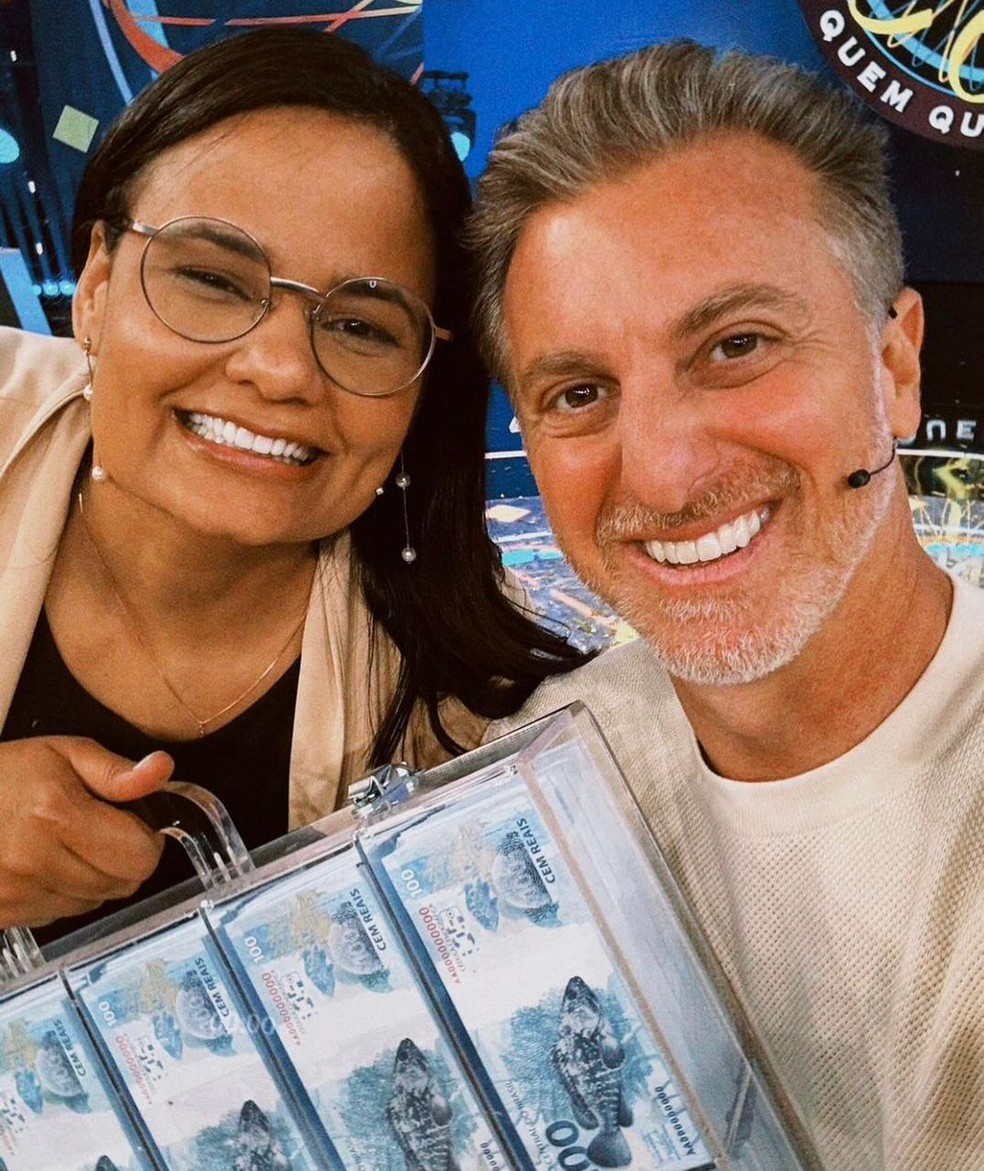 Jullie Dutra, primeira pessoa a ganhar o prêmio máximo do "Quem quer ser um milionário", com Luciano Huck. — Foto: Reprodução / Instagram