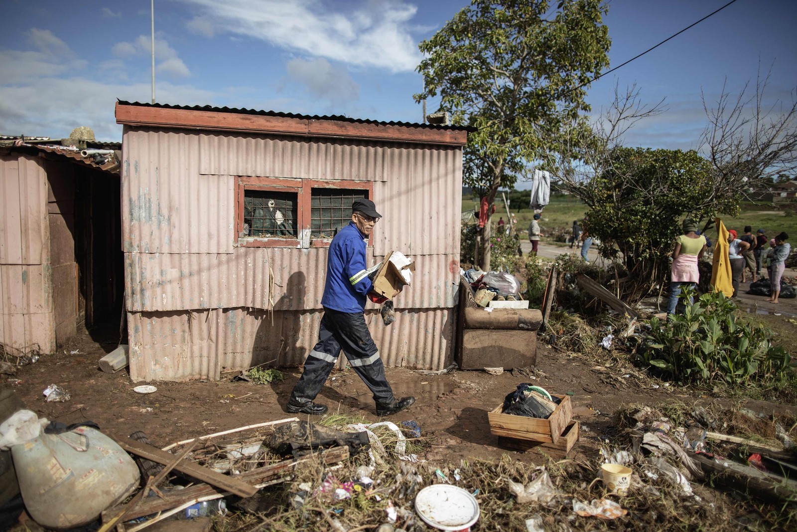 Moradores limpam as águas das enchentes de suas casas. As enchentes causadas por chuvas torrenciais e ventos fortes na costa leste da África do Sul mataram pelo menos 22 pessoas, disseram as autoridades locais na terça-feira. As inundações atingiram vários locais em duas províncias do leste, dois raros tornados foram detectados, as temperaturas caíram e a neve caiu em algumas regiões centrais. — Foto: GIANLUIGI GUERCIA/AFP