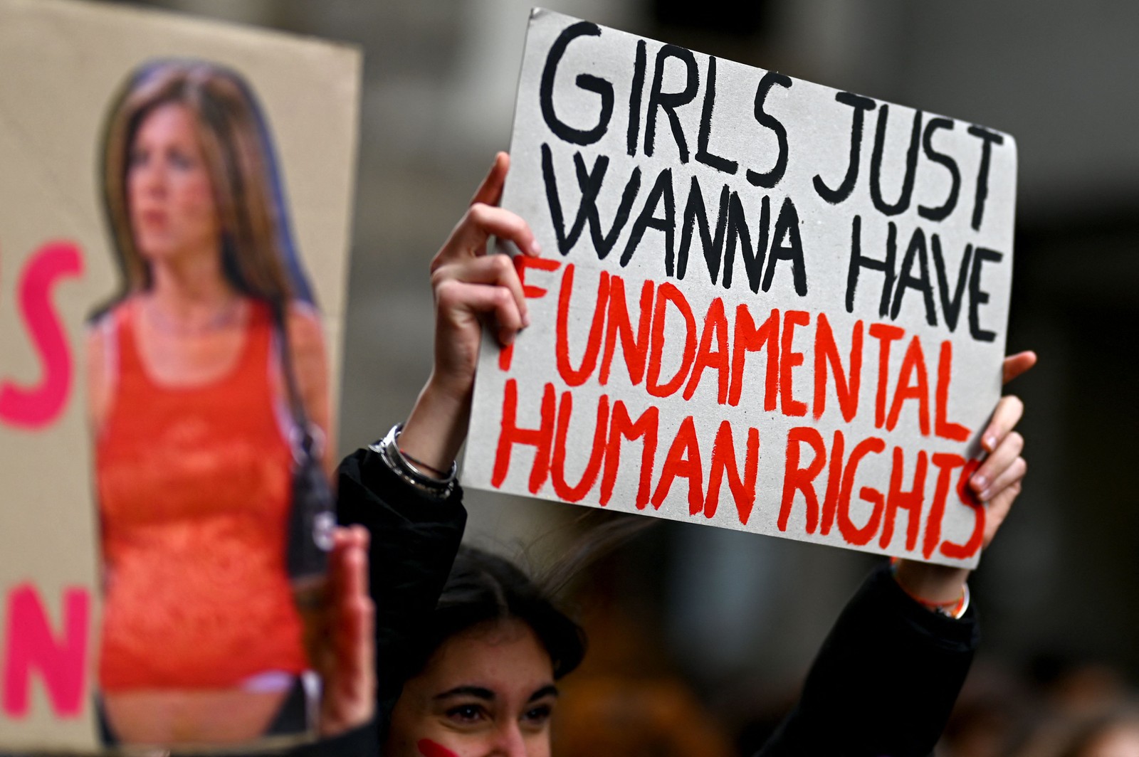 Referenciando a icônica música da cantora Cyndi Lauper, uma manifestante segura o cartaz: "Girls just wanna have fun(damental human rights" (Garotas só querem ter direitos humanos básicos) em Milão, Itália — Foto: GABRIEL BOUYS