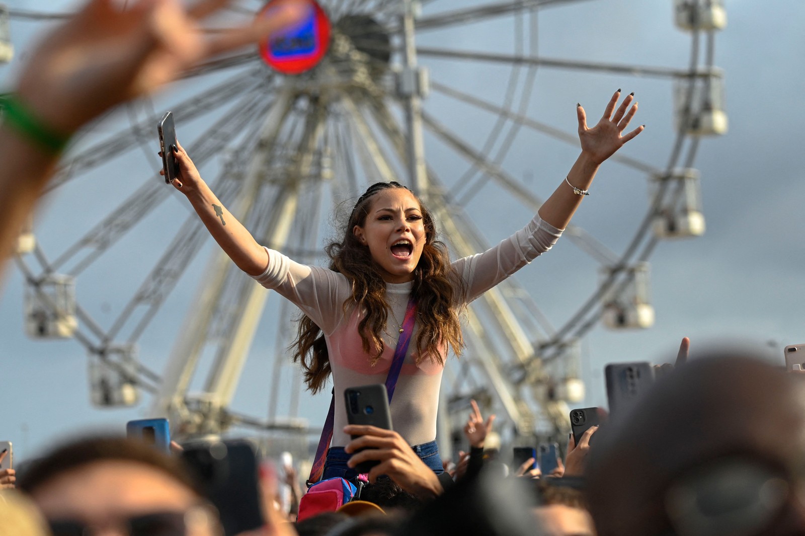 Fã sobe nos ombros para cantar com o show do Papatinho no Palco Sunset — Foto: Mauro Pimentel/AFP