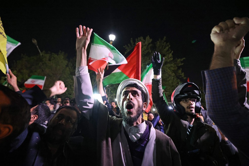 Manifestantes agitam bandeiras do Irã e da Palestina durante ato em Teerã, em comemoração ao ataque contra Israel — Foto: Atta Kenare/AFP