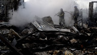 Bombeiros apagam incêndio em área industrial de Kiev atingida por bombardeio. — Foto: Sergei Supinsky/AFP