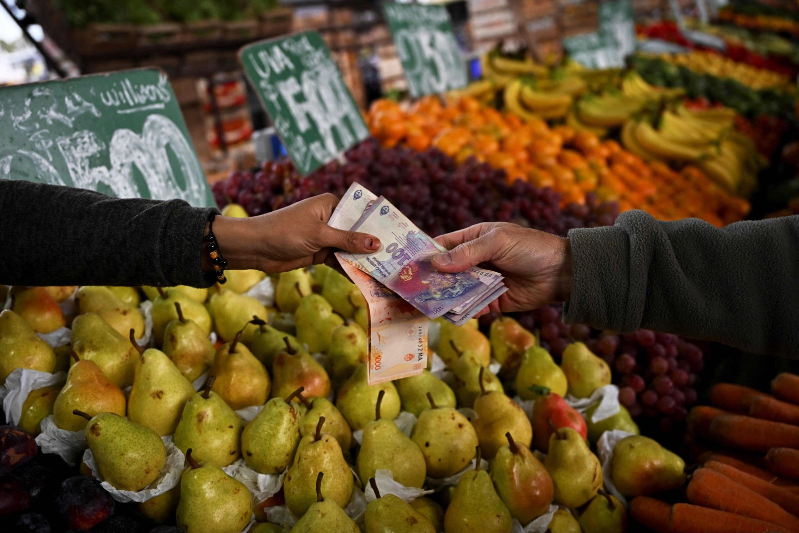 Um homem compra frutas e verduras no Mercado Central de Buenos Aires. Em meio a crise, o país criou nova cédula de 2000 pesos argentinos. — Foto: Luis ROBAYO / AFP