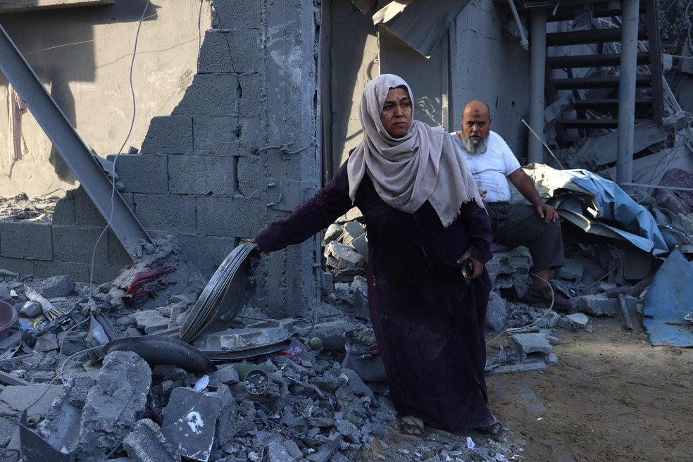 Palestinos sobre os escombros de Rafah, ao sul da Faixa de Gaza, depois de intenso bombardeio de Israel — Foto: SAID KHATIB / AFP