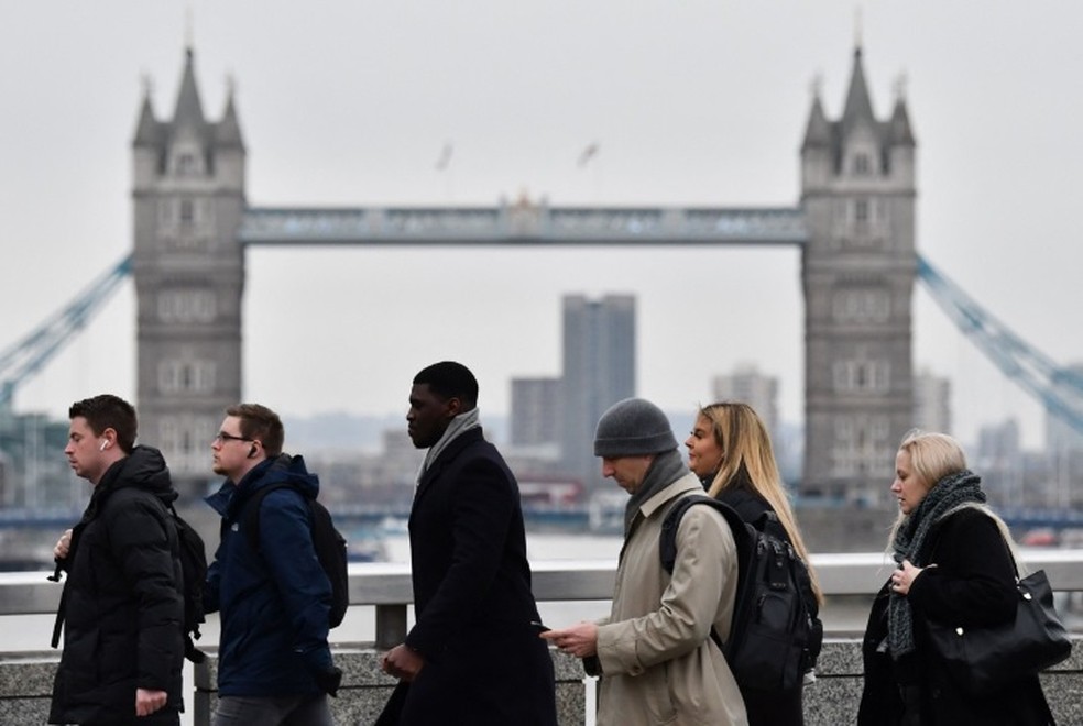 Pessoas caminham em Londres: cidade será uma das que vão testar jornada reduzida de quatro horas — Foto: AFP