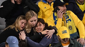 Torcedores suecos assustados esperam para sair na arquibancada durante o jogo interrompido de qualificação para o Euro 2024 entre Bélgica e Suécia — Foto: JOHN THYS/AFP