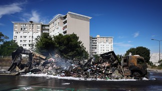 Caminhão de mercadorias queimado perto de uma loja Aldi no bairro de Les Flamants, no norte de Marselha, sul de França, em 1º de julho de 2023, após uma quarta noite consecutiva de protestos no país — Foto: CLEMENT MAHOUDEAU / AFP