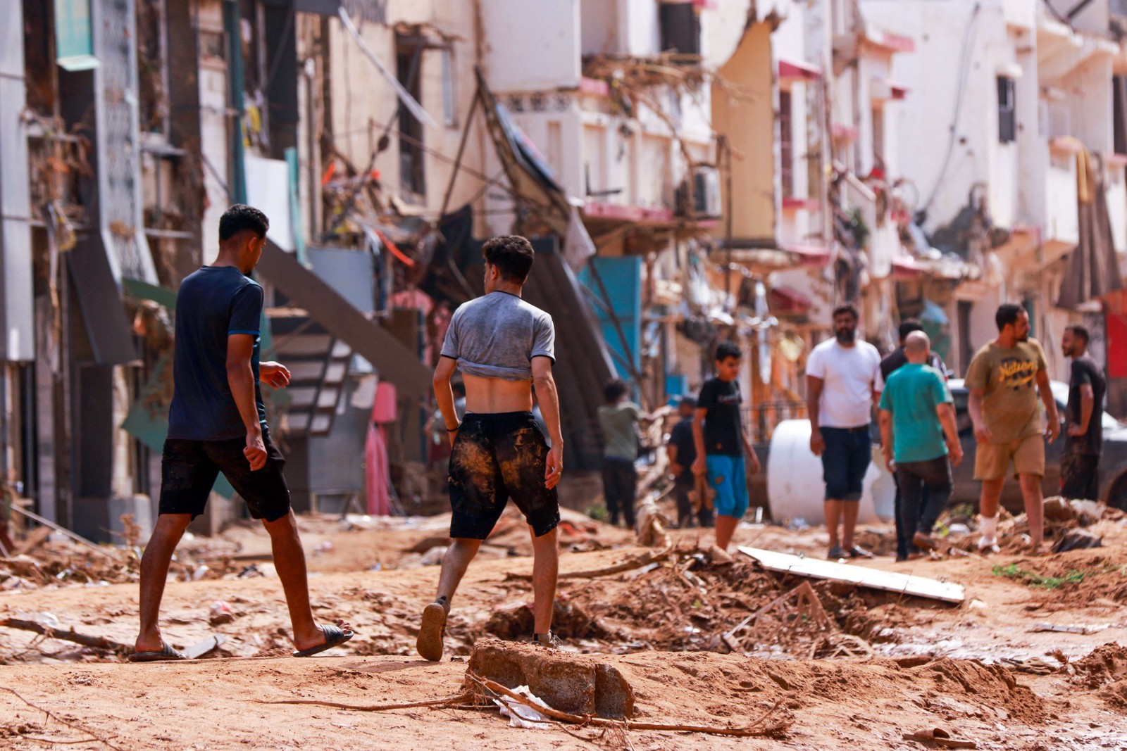Pessoas verificam uma área danificada por inundações repentinas em Derna, no leste da Líbia — Foto: AFP