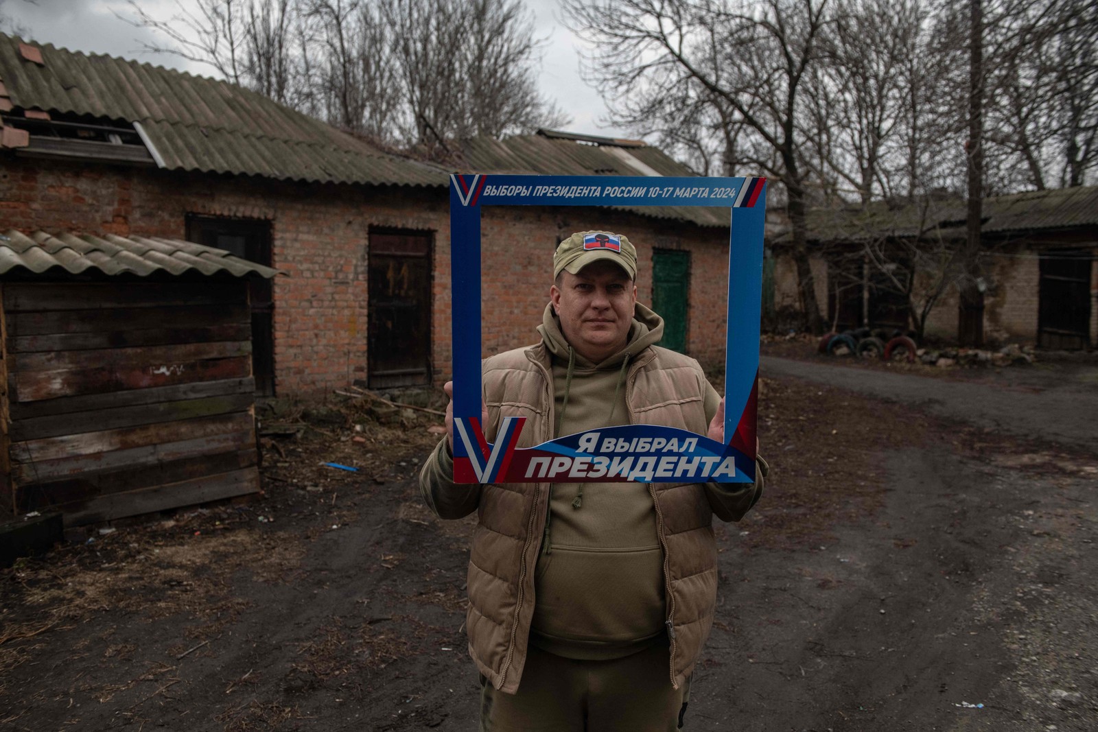 Homem posa com uma moldura em que se lê "Escolhi um presidente" em Donetsk, na Ucrânia, controlada pela Rússia, em meio ao conflito Rússia-Ucrânia — Foto: AFP
