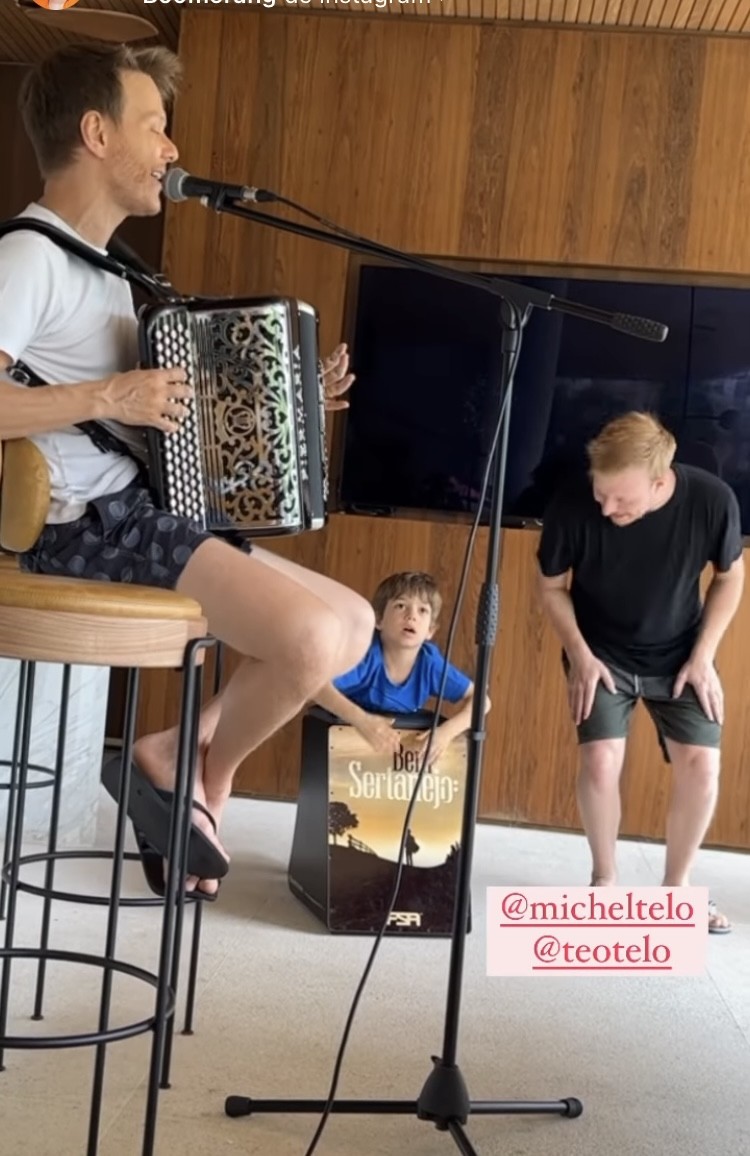 Enquanto Michel Teló canta, Teo Teló brinca com o sobrinho Teodoro na área externa da casa — Foto: Reprodução/Instagram